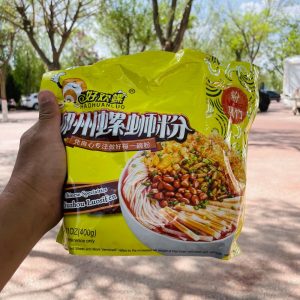 มือกำลังถือห่อบะหมี่หลัวซือเฝิ่นยี่ห้อ 好欢螺